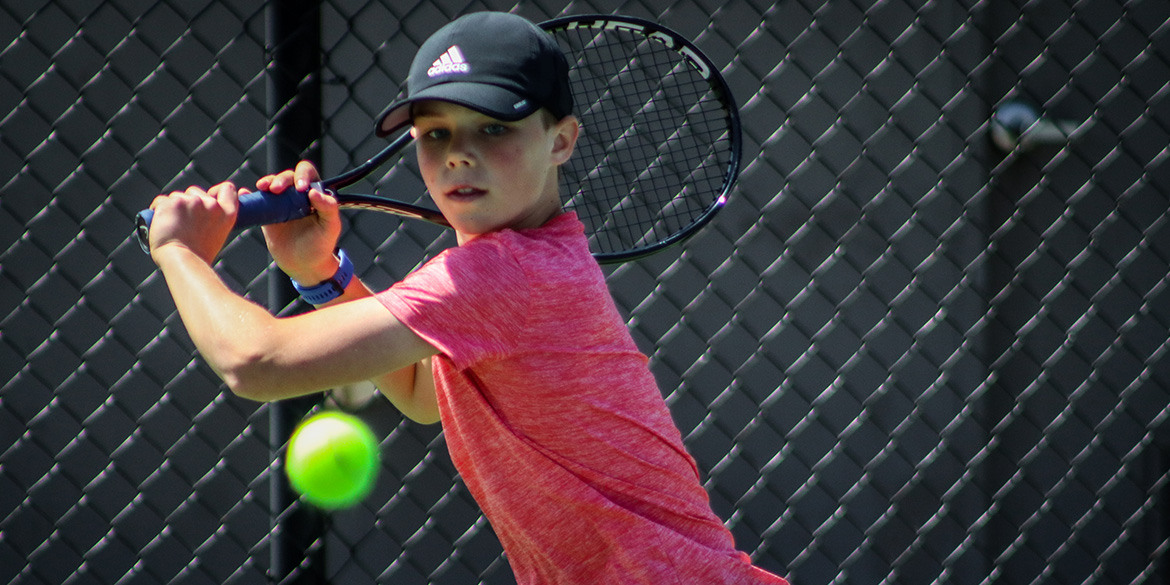 young boy playing tennis